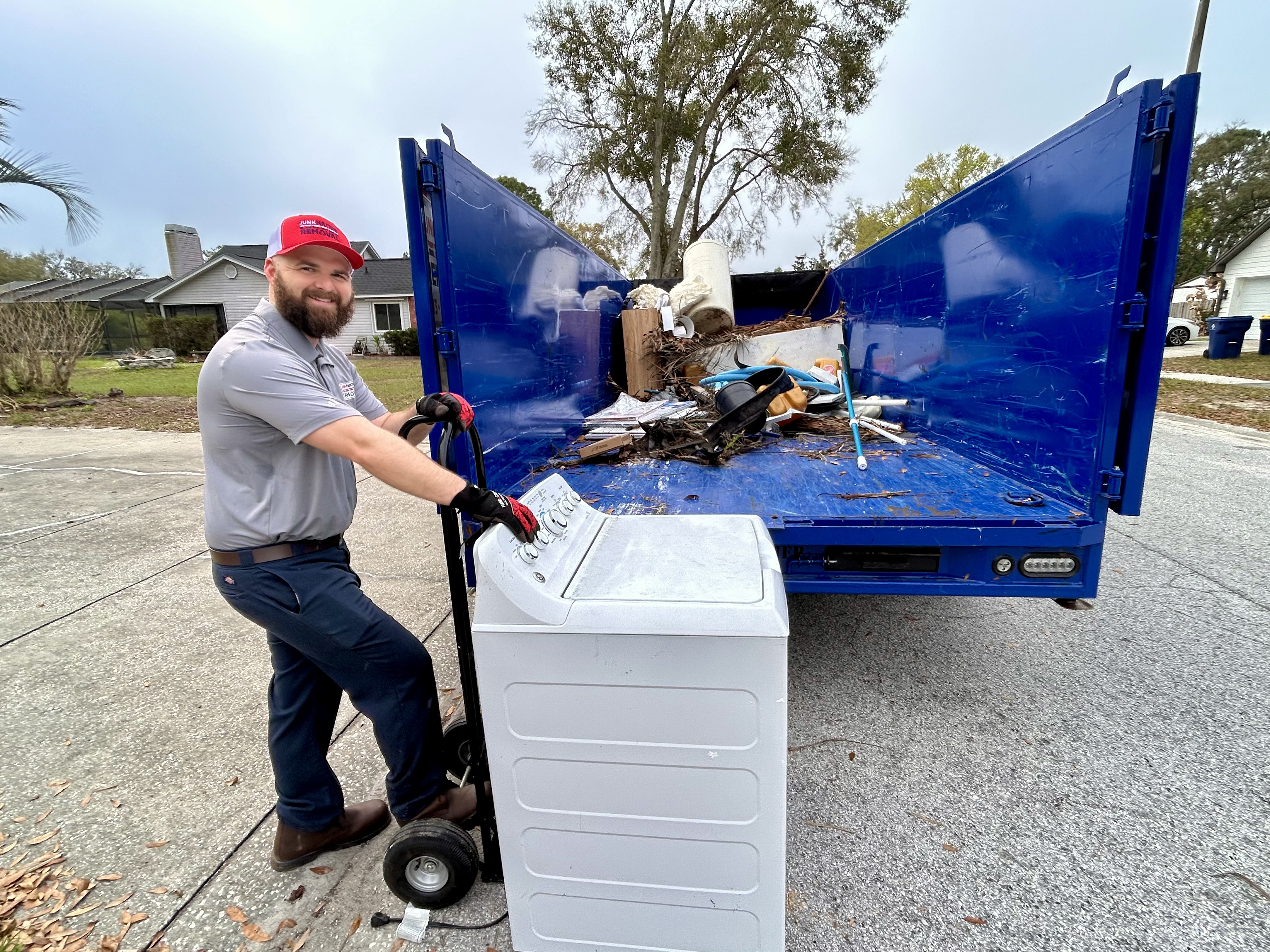Crew member removing washing machine appliance
