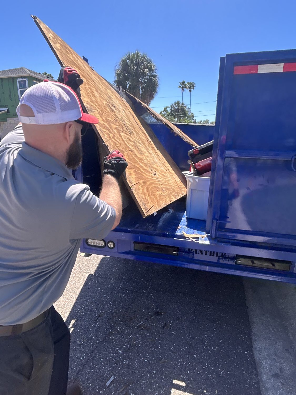 Junk Nation Removal crew loading construction debris and lumber into the trailer