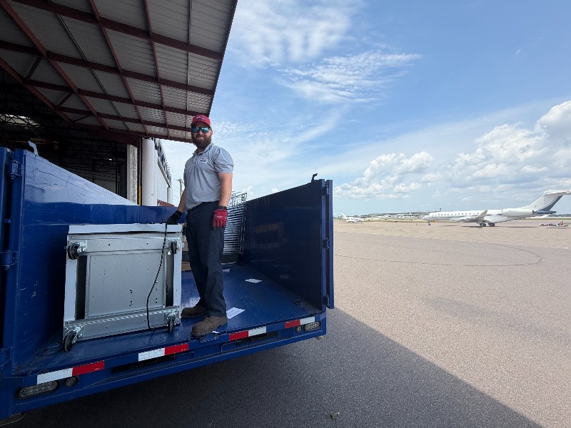 Junk Nation Removal crew loading items into the trailer at a Tampa Bay aircraft hangar