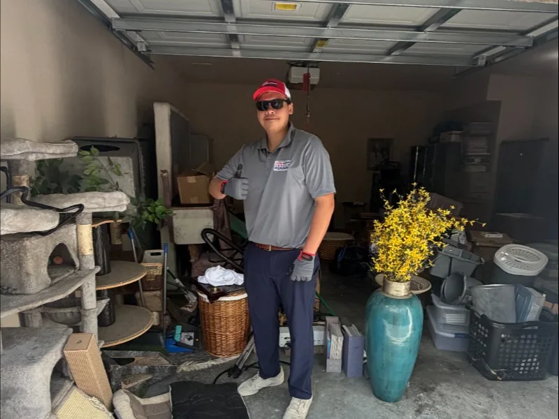 Junk Nation Removal team member inside a cluttered garage before a cleanout