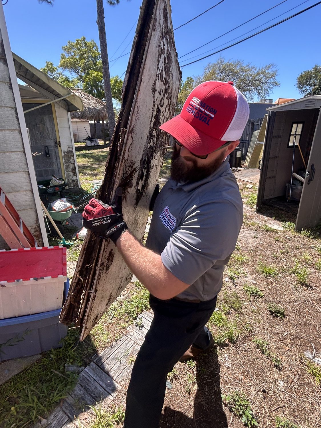 Junk Nation Removal team member removing storm debris from a property