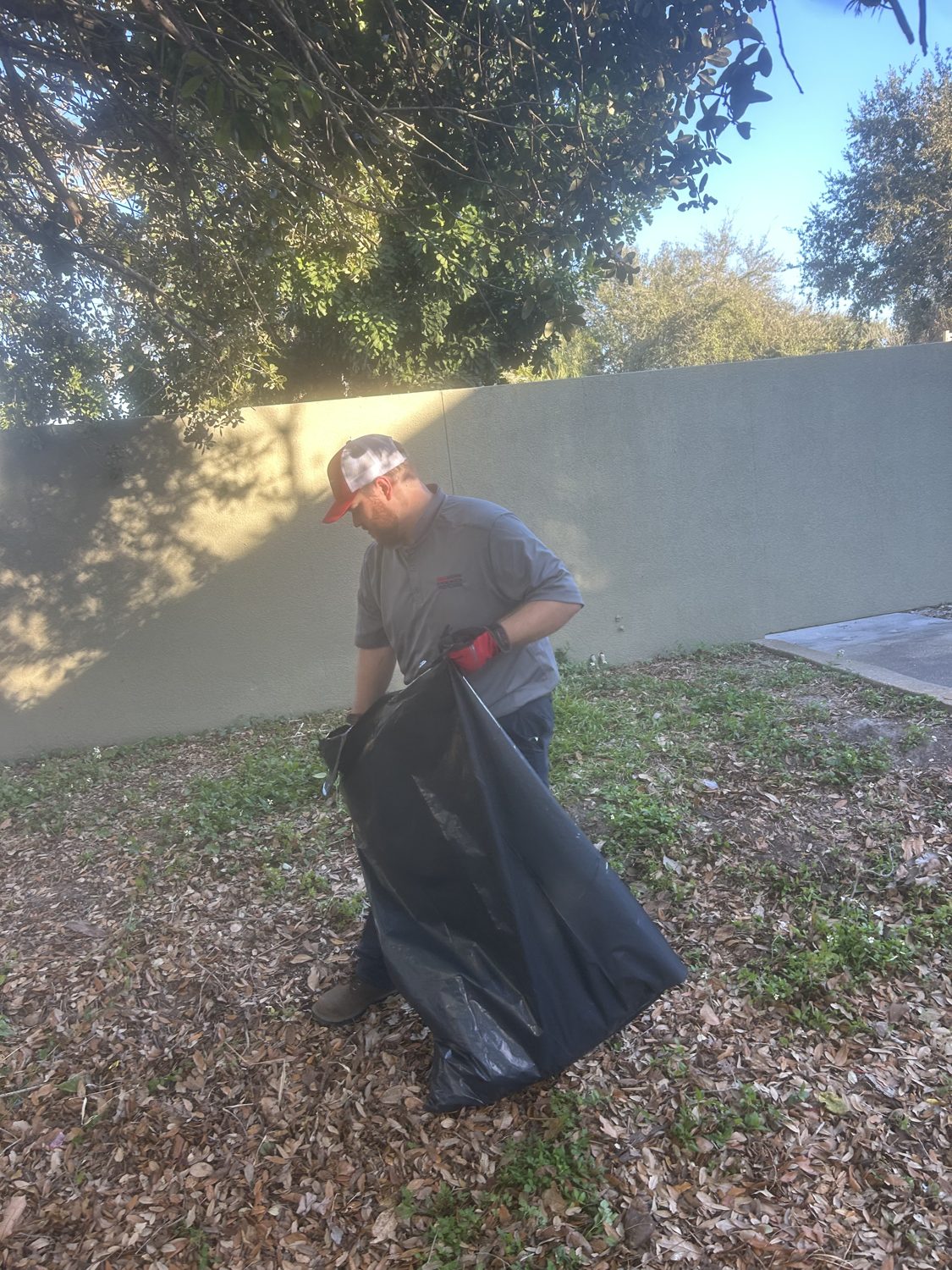 Junk Nation Removal team member bagging yard debris and leaves