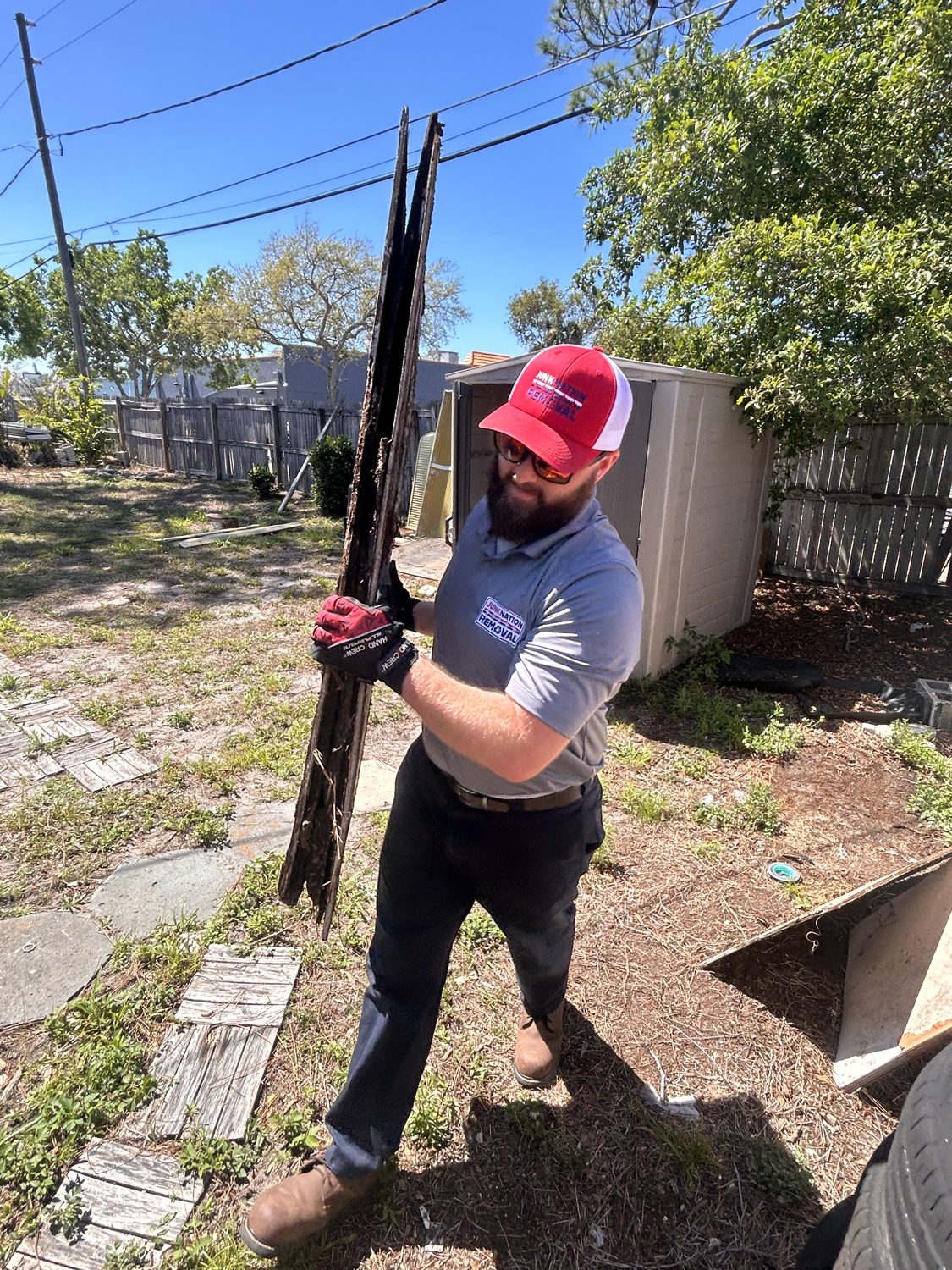 Junk Nation Removal team member clearing yard waste from a Tampa Bay backyard